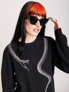 sweater with skeleton snake detail around neck.