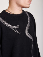 sweater with skeleton snake detail around neck.