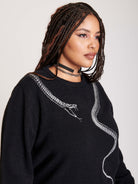 sweater with skeleton snake detail around neck.