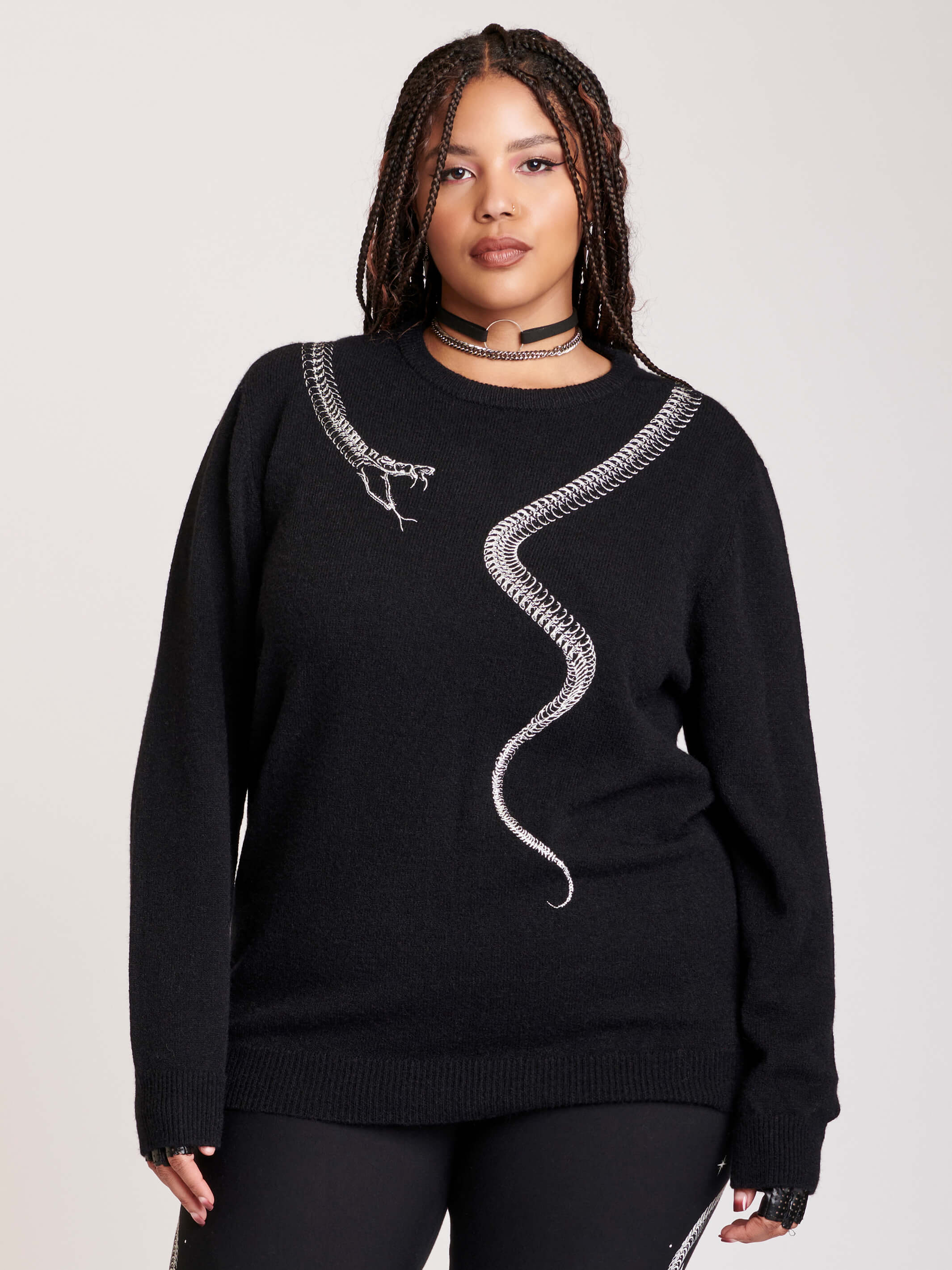 sweater with skeleton snake detail around neck.