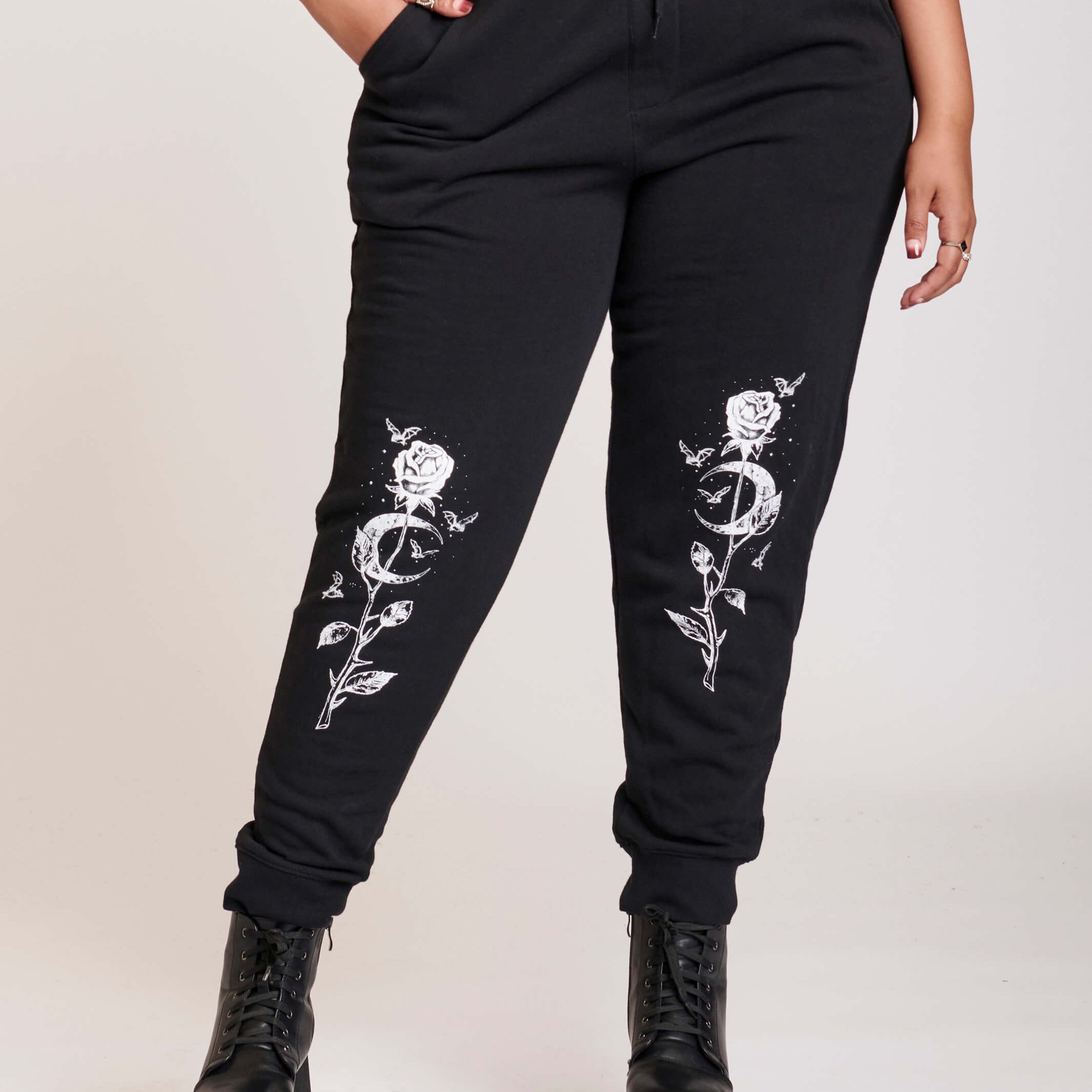 Black jogger with white rose and cresecent moon art at knees